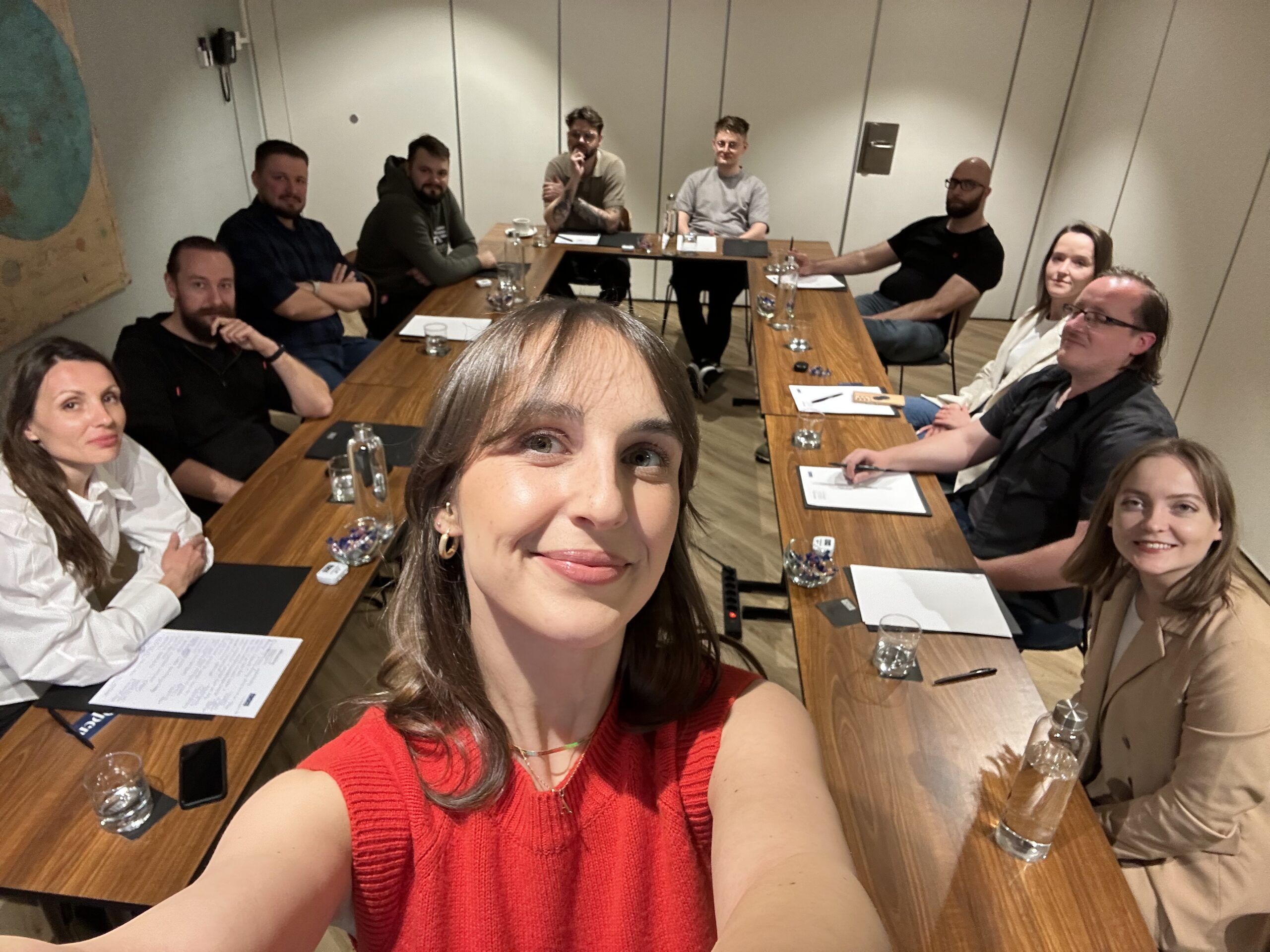Selfie des Projektleiters mit einem Team auf einer Konferenz, alle zusammen lächelnd
